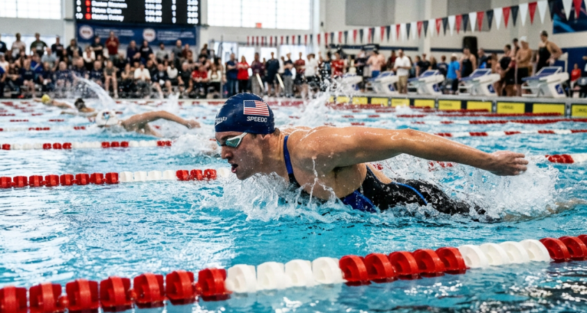 Swimmer performing butterfly stroke in a competitive swimming pool race